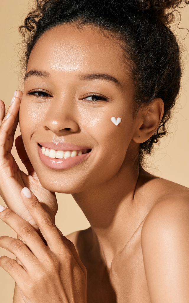 Woman with a heart shaped skincare product on face
