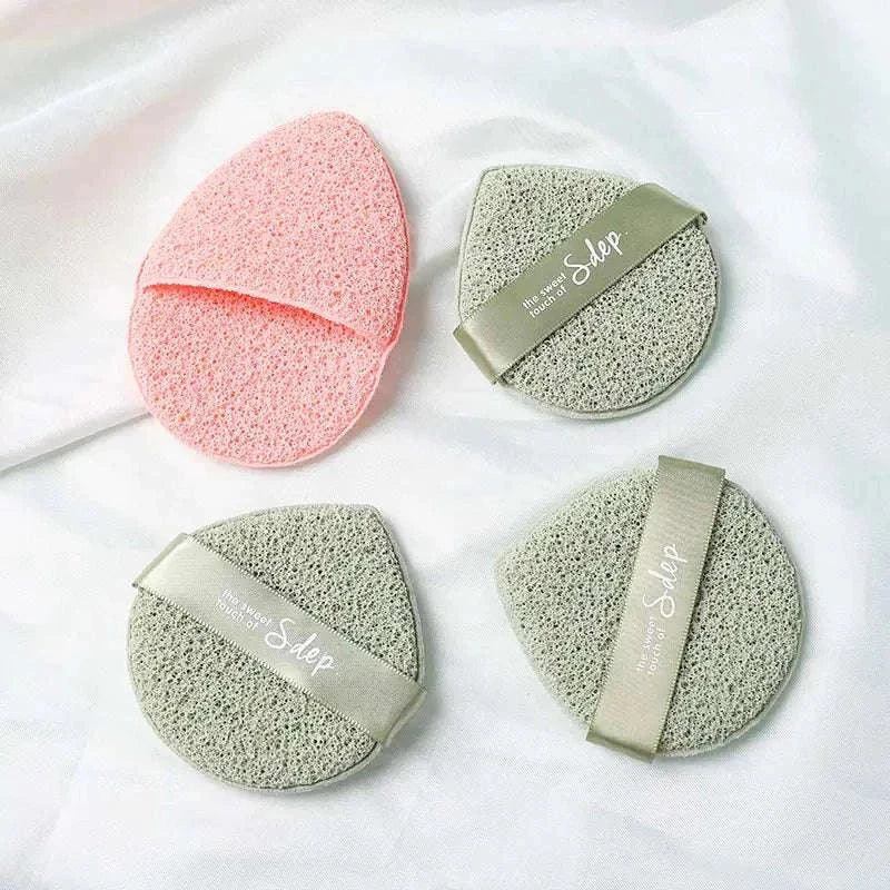 Travel-ready exfoliating face puff set with soft textured sponges and hand straps for gentle facial cleansing and exfoliation.