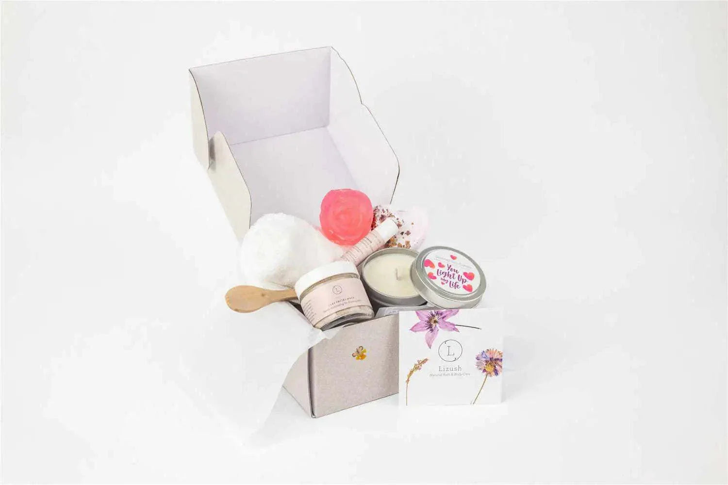 Cherish Skincare Luxury Gift Box for Her with natural spa items including clay mask, lavender bath bomb, soy candle, lip balm, soap, face towel, and personalized box