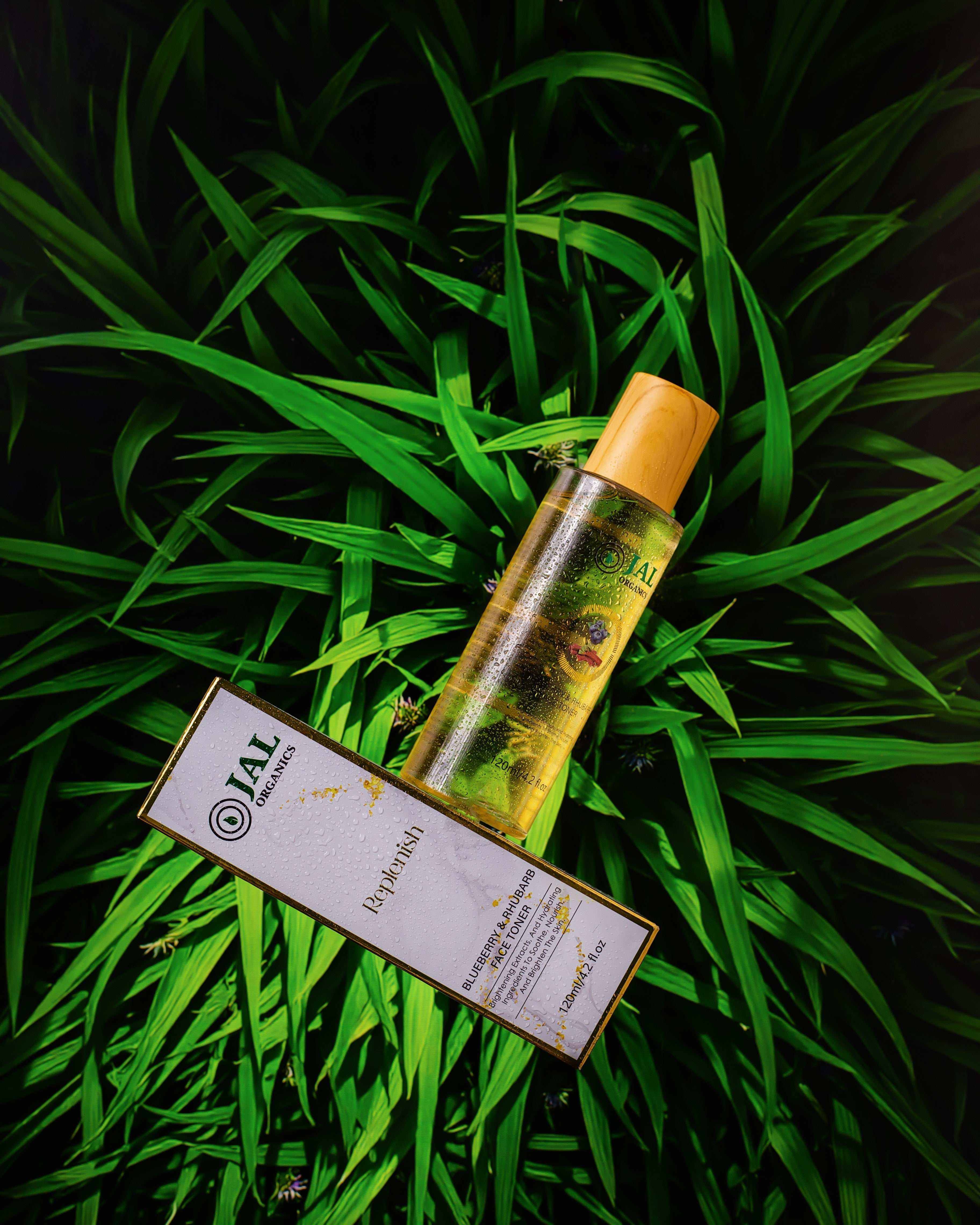 Blueberry and Rhubarb Toner bottle on lush green background.