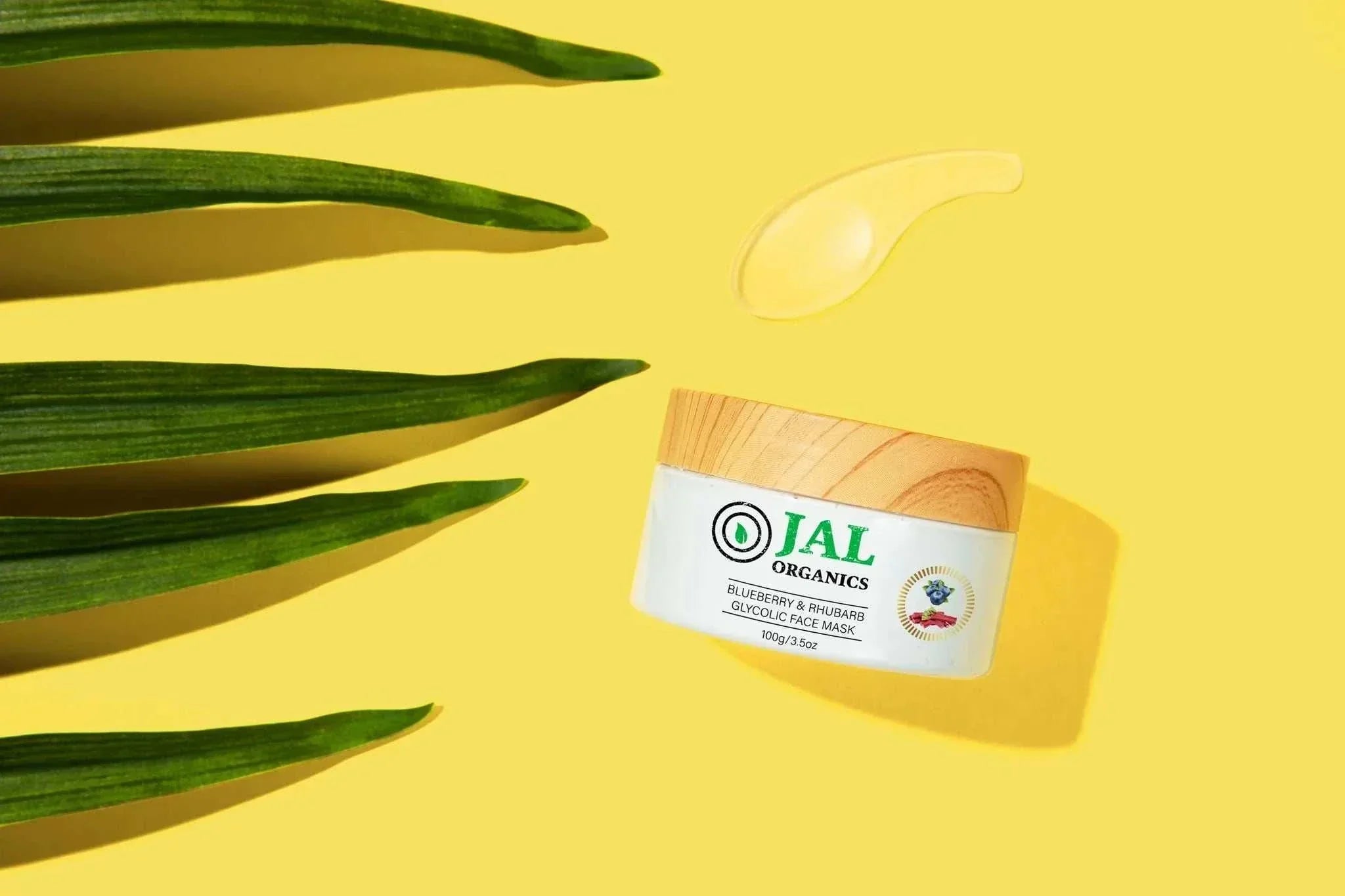 5-Piece Blueberry Rhubarb Skin Care Set on yellow background with leaves and gel.