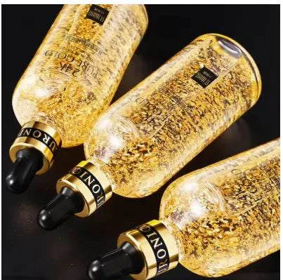 Three bottles of 24K Gold Hyaluronic Rejuvenating Serum with visible gold flakes inside