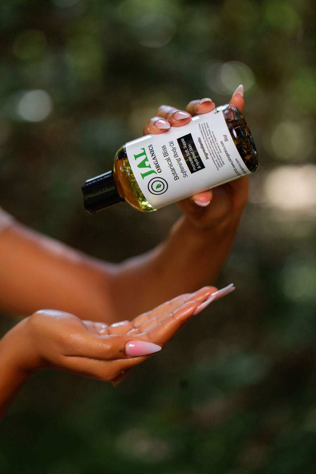 Botanical Bliss Body Oil being poured into a hand for application.