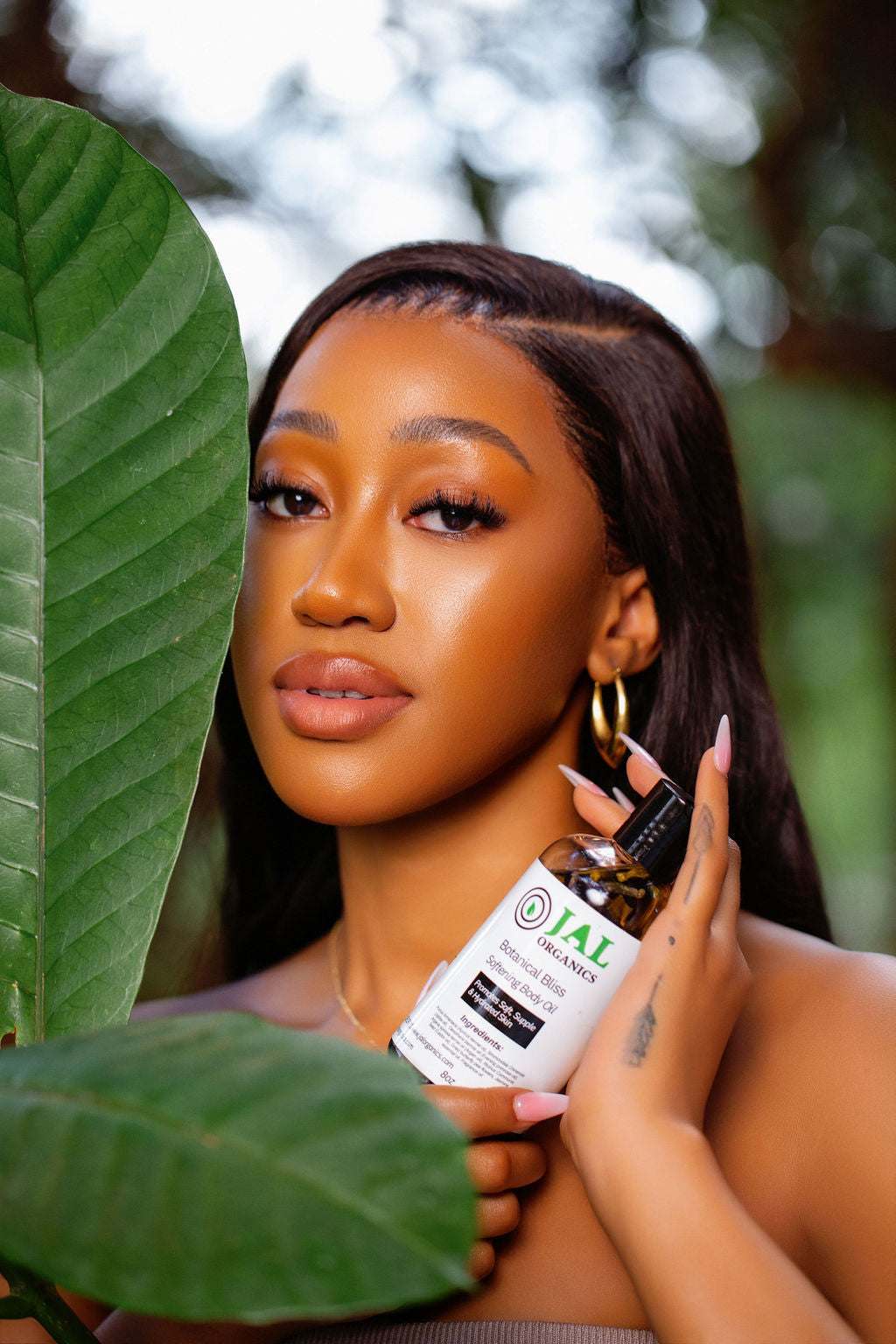 Botanical Bliss Body Oil being held by a person in a natural setting.