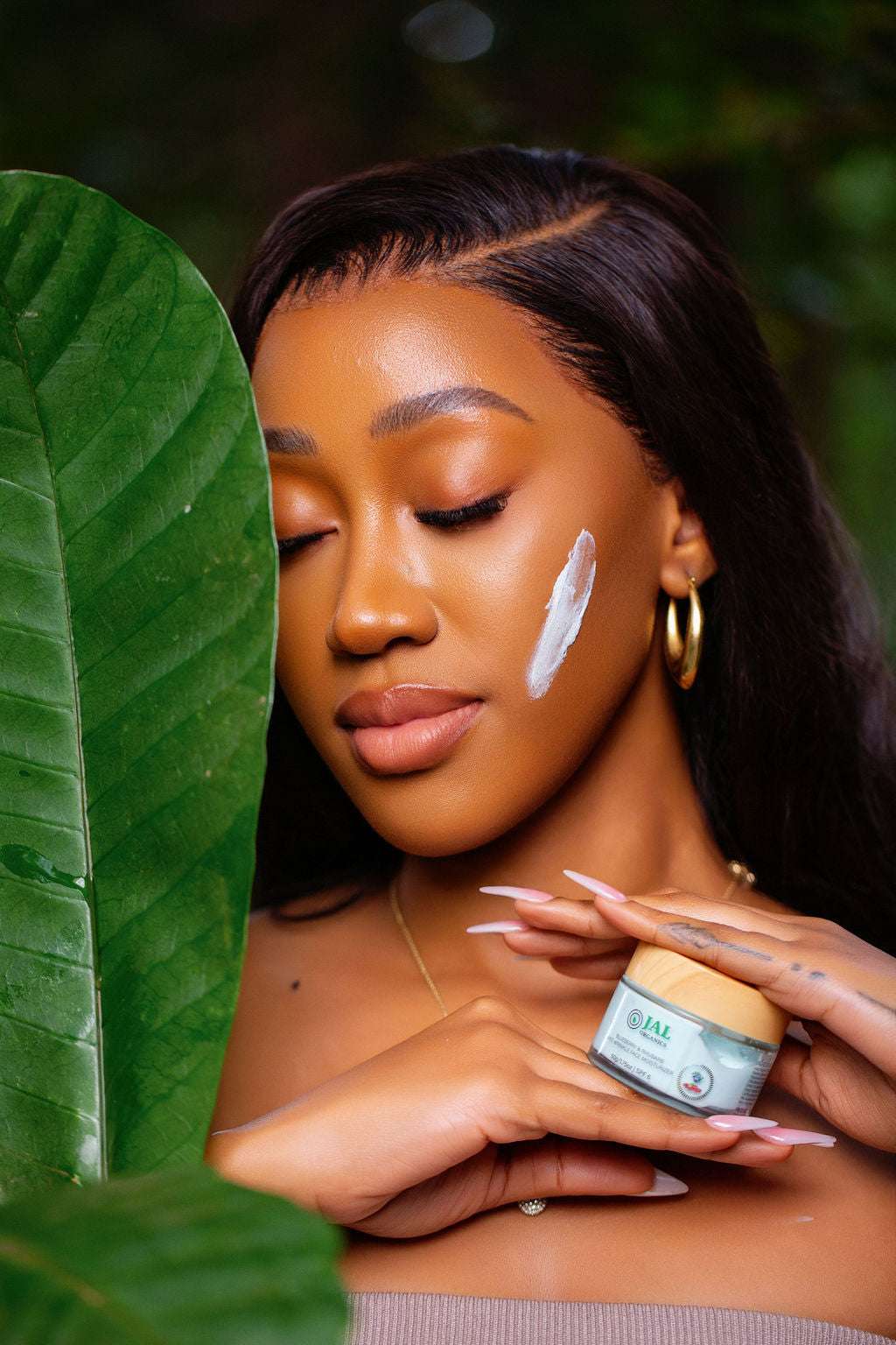 Blueberry Rhubarb Anti-wrinkle face cream applied on woman's cheek amidst lush greenery.