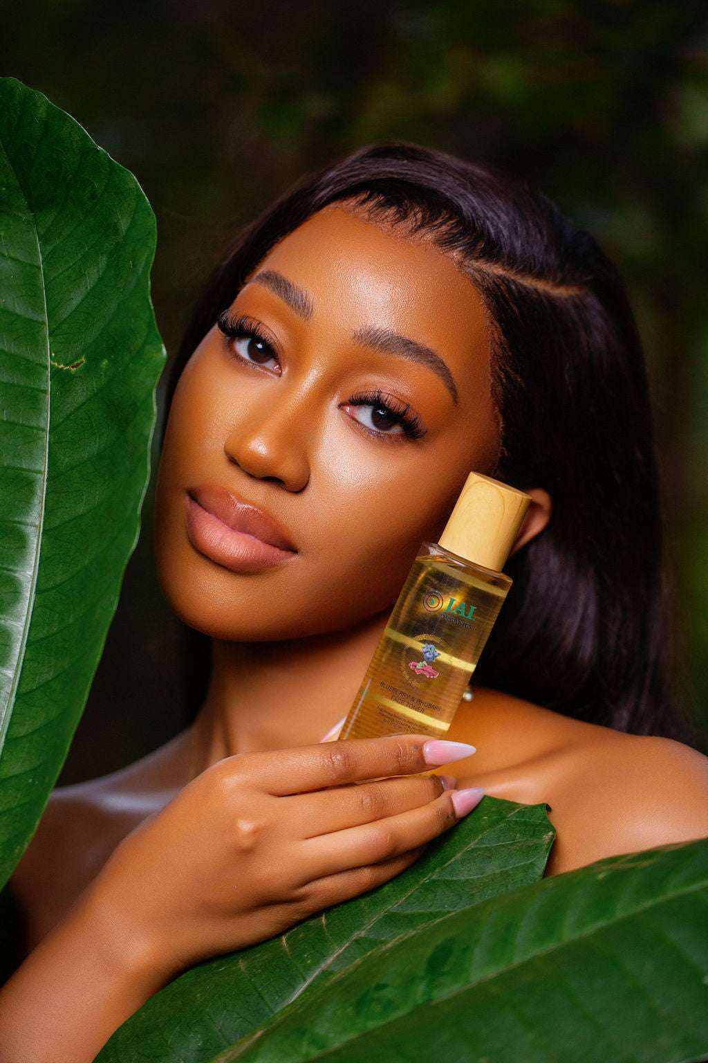Blueberry and Rhubarb Toner held by woman surrounded by green leaves.
