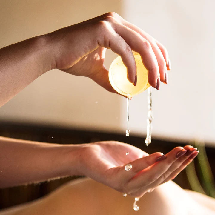 Woman pouring bath oil into hands